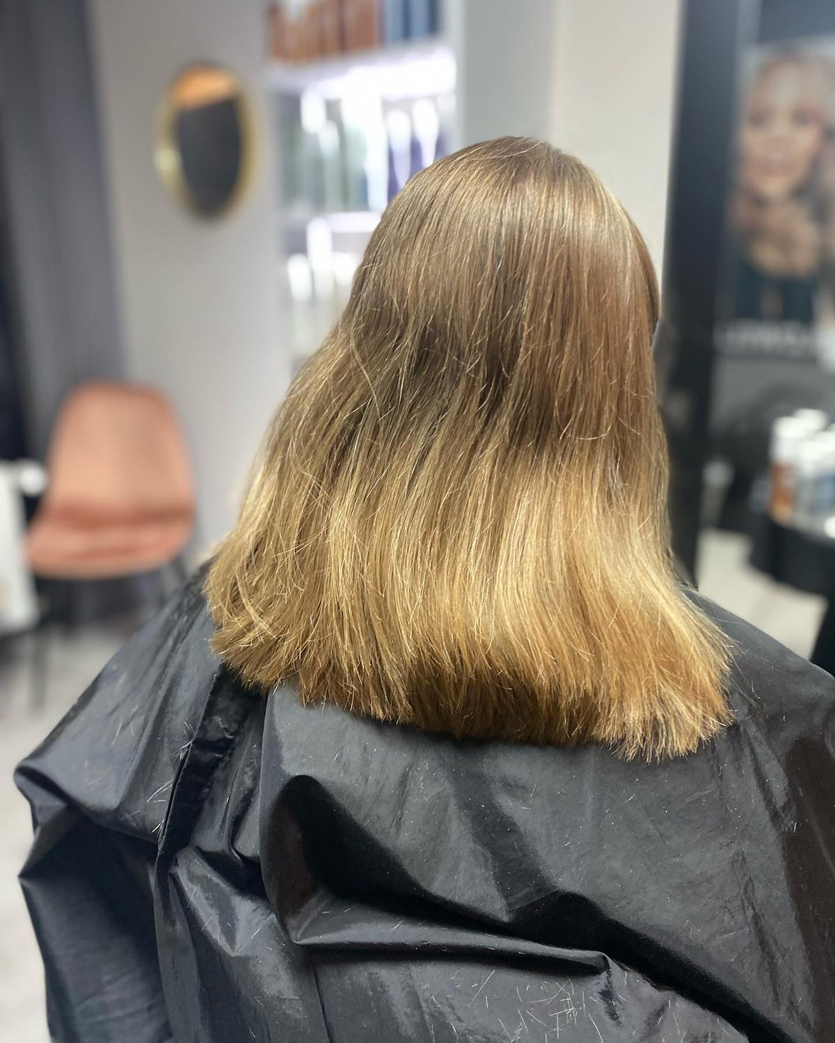 Blond haar tot op de schouders, van achteren gezien in de salon