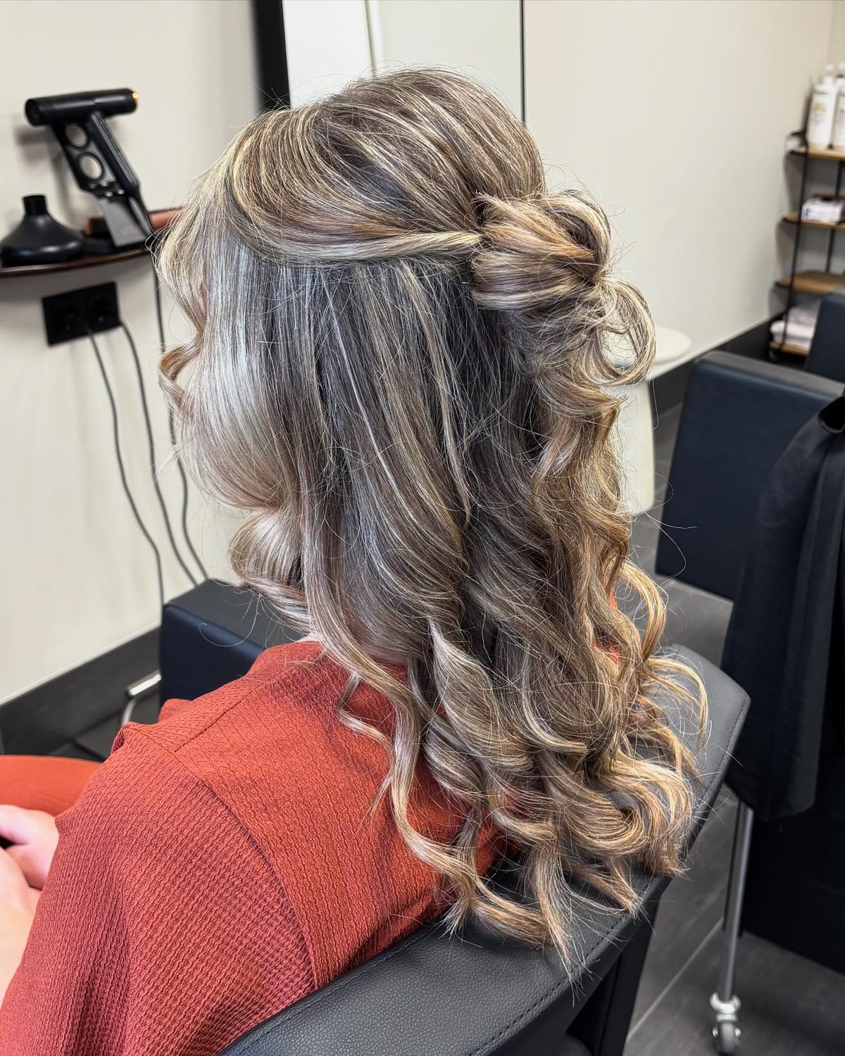 Half opgestoken kapsel met krullen en highlights